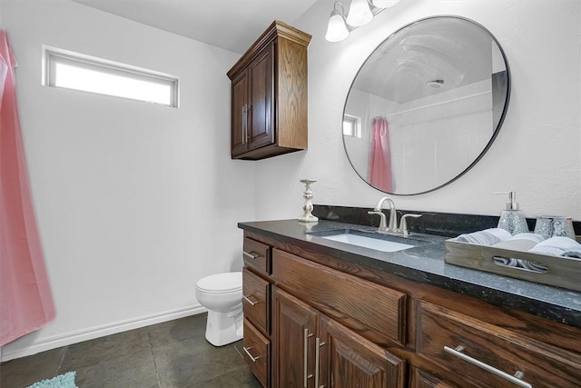 bathroom featuring toilet, tile patterned floors, vanity, and curtained shower