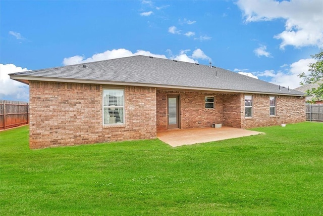 rear view of property with a lawn and a patio