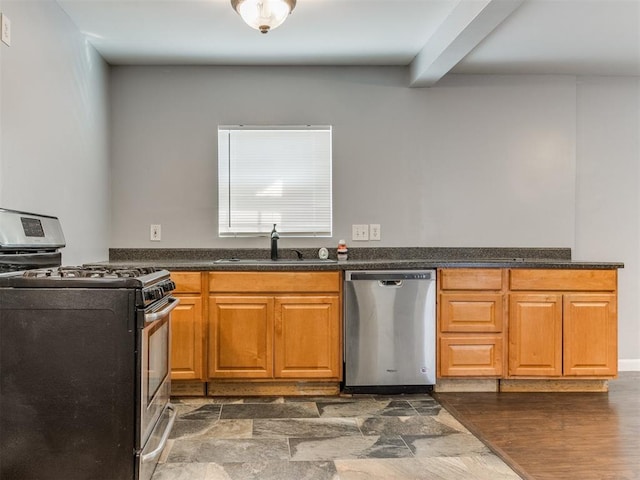 kitchen with appliances with stainless steel finishes, dark hardwood / wood-style floors, beam ceiling, and sink