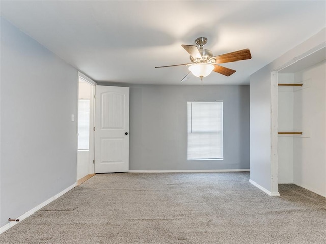 carpeted spare room featuring ceiling fan