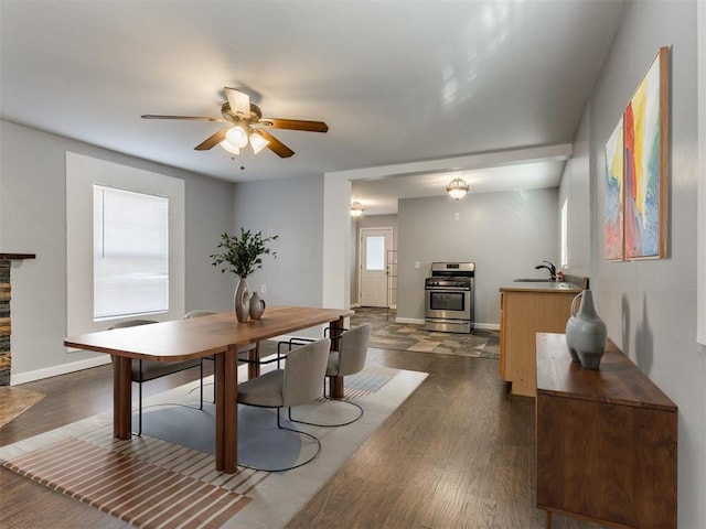 dining area featuring sink, ceiling fan, and dark hardwood / wood-style floors