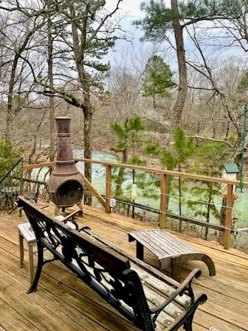 wooden terrace with an outdoor fireplace