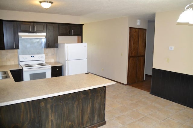 kitchen featuring backsplash, white appliances, dark brown cabinets, and kitchen peninsula