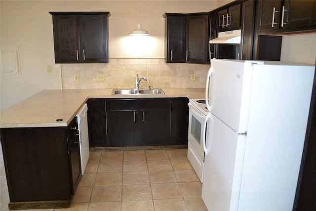 kitchen featuring light tile patterned floors, sink, white appliances, hanging light fixtures, and kitchen peninsula