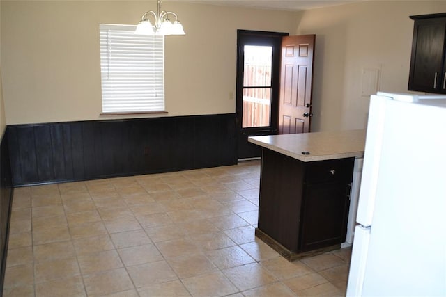 kitchen featuring hanging light fixtures, light tile patterned flooring, white fridge, and a notable chandelier