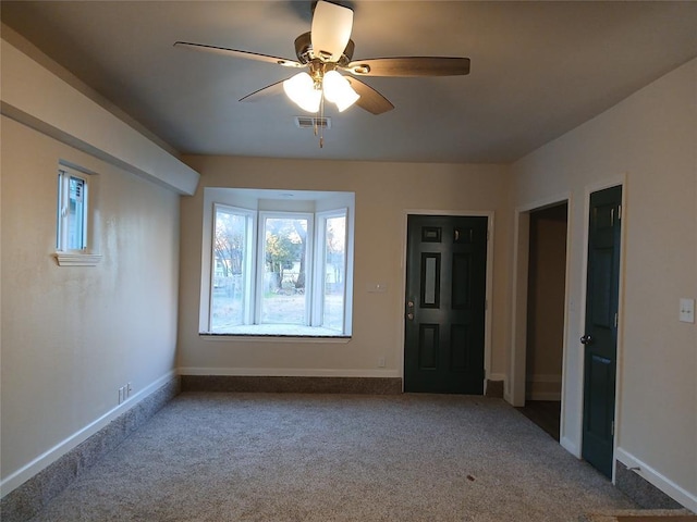 empty room featuring ceiling fan and carpet floors