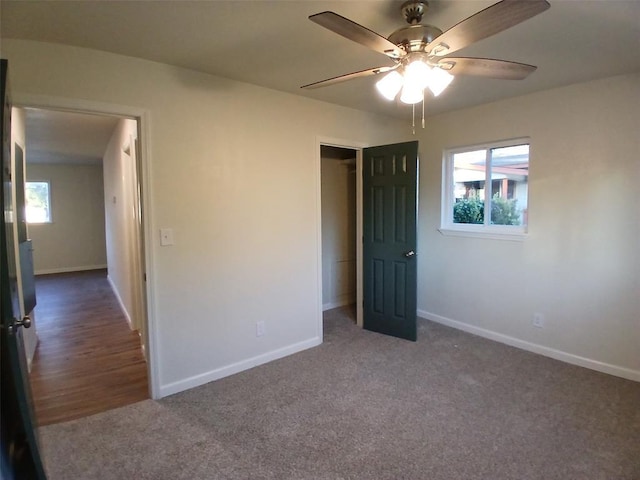 unfurnished bedroom featuring ceiling fan and dark colored carpet