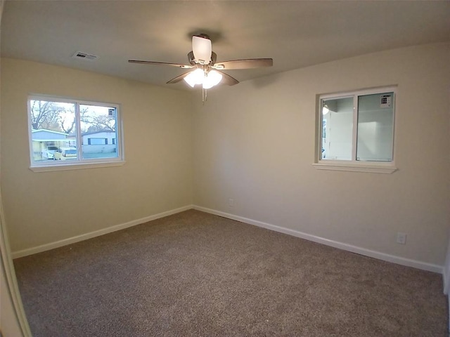 empty room with dark carpet and ceiling fan