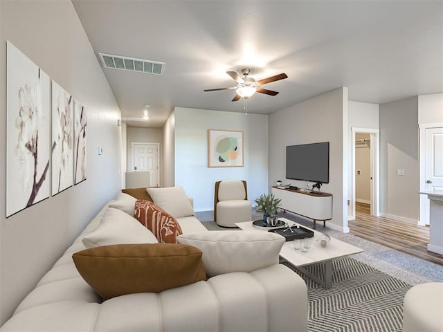 carpeted living room featuring ceiling fan