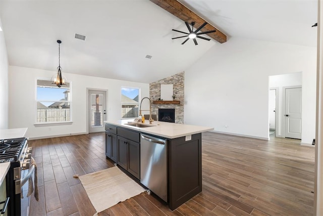 kitchen featuring a wealth of natural light, pendant lighting, stainless steel appliances, an island with sink, and sink