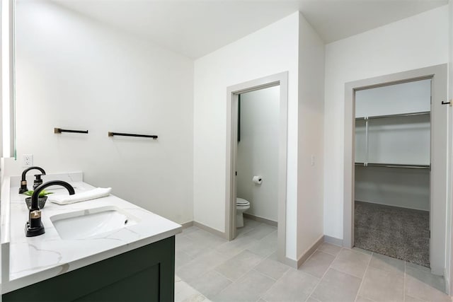 bathroom with tile patterned flooring, vanity, and toilet