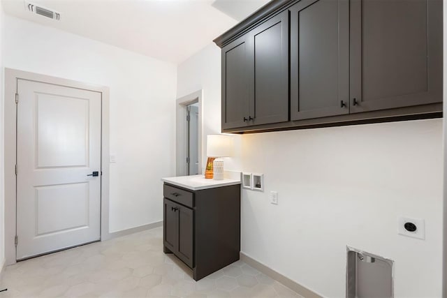 washroom featuring light tile patterned floors, electric dryer hookup, hookup for a washing machine, and cabinets