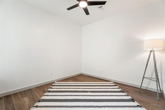 empty room with ceiling fan, lofted ceiling, and dark hardwood / wood-style floors