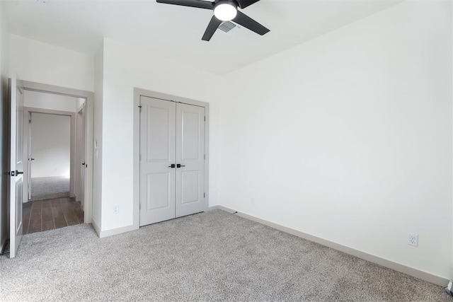 unfurnished bedroom featuring ceiling fan, a closet, and light carpet