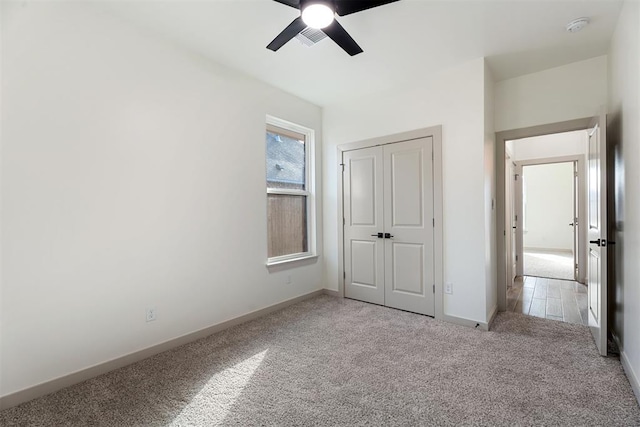 unfurnished bedroom with a closet, ceiling fan, and light carpet