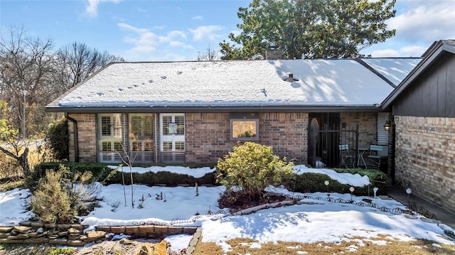 view of snow covered back of property