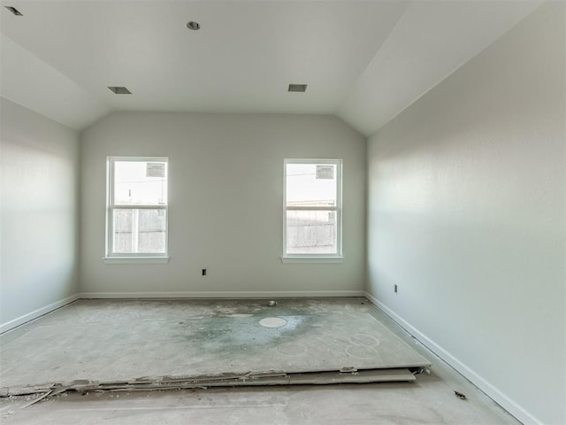 empty room featuring plenty of natural light and vaulted ceiling