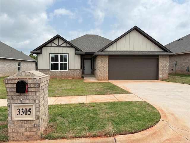 3305 NW 178th Ter, Edmond, OK 73012 - view of front of property featuring board and batten siding, brick siding, a garage, a shingled roof, and a front lawn