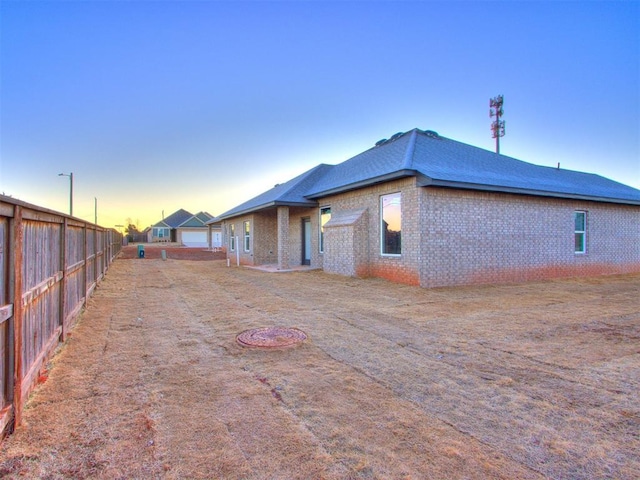 3305 NW 178th Ter, Edmond, OK 73012 - back of property at dusk featuring brick siding