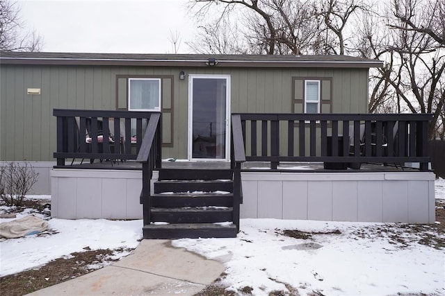 snow covered house with a deck