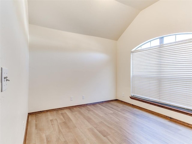 empty room with lofted ceiling and light hardwood / wood-style floors