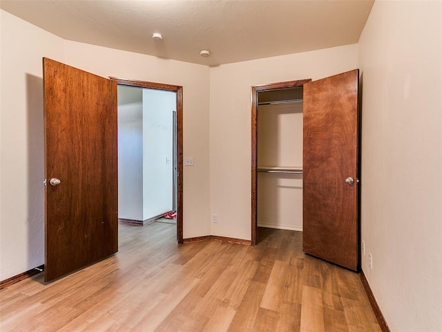 unfurnished bedroom with a closet and light hardwood / wood-style flooring