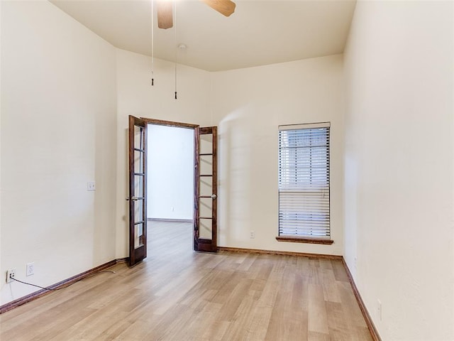 spare room with ceiling fan, french doors, and light wood-type flooring