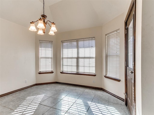 tiled spare room featuring a notable chandelier