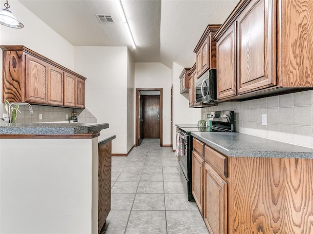 kitchen with vaulted ceiling, stainless steel appliances, light tile patterned floors, decorative backsplash, and sink