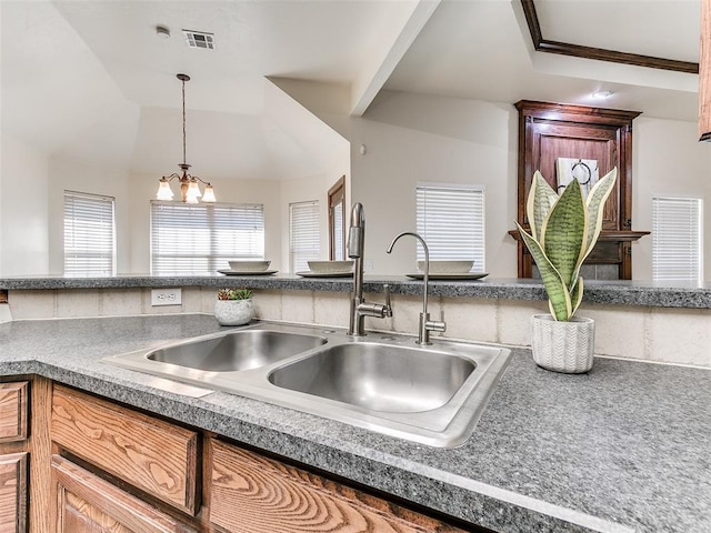 kitchen featuring vaulted ceiling, a chandelier, hanging light fixtures, crown molding, and sink