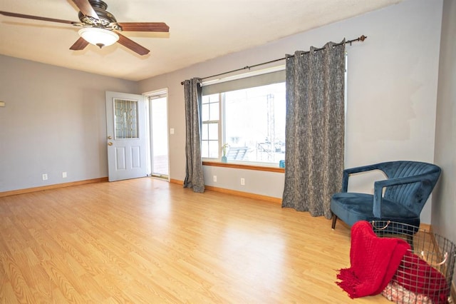 living area featuring light wood-type flooring and ceiling fan