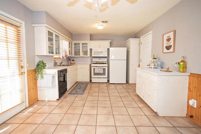 kitchen featuring white appliances, white cabinetry, a healthy amount of sunlight, and light tile patterned floors