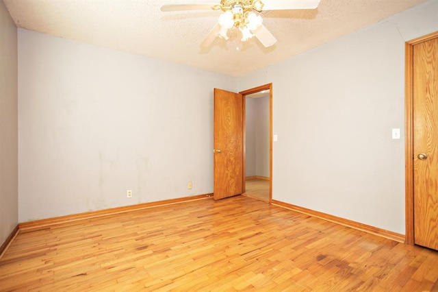 empty room featuring light hardwood / wood-style floors, ceiling fan, and a textured ceiling