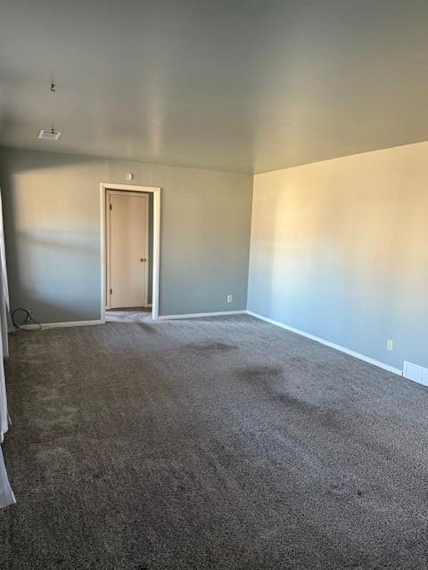 spare room featuring dark colored carpet