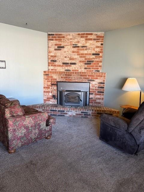 living room with a textured ceiling, a wood stove, and carpet floors