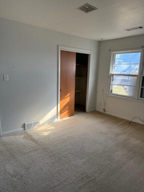 unfurnished bedroom featuring a closet and light carpet