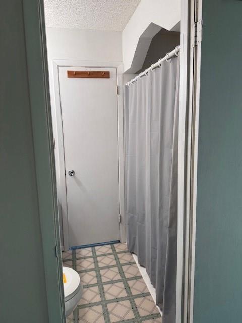 bathroom featuring toilet and a textured ceiling