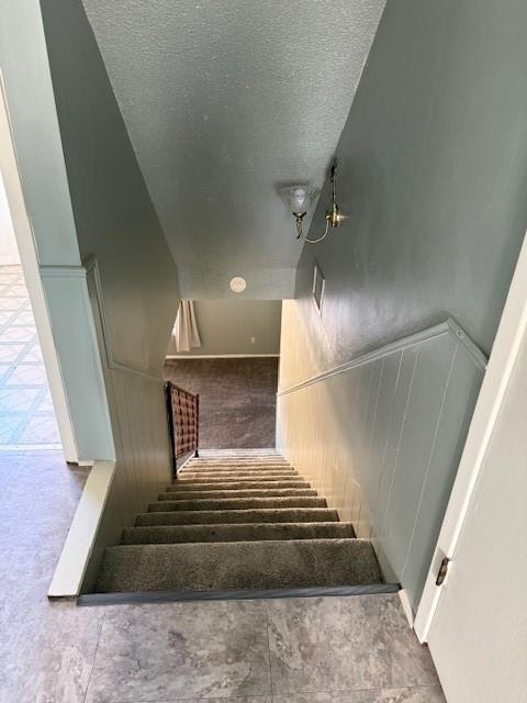 stairway featuring a textured ceiling