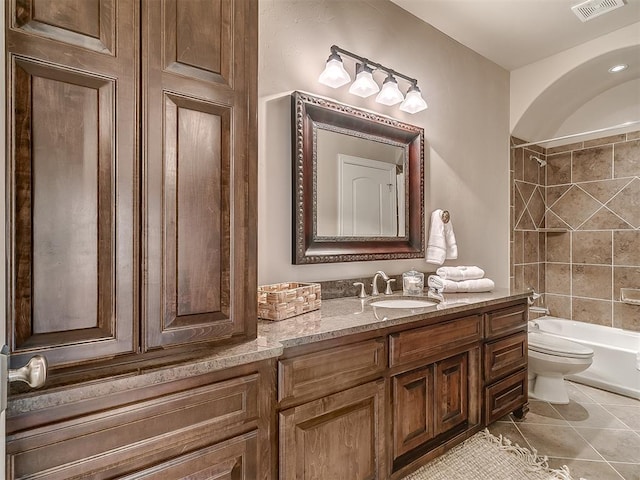 full bathroom with tiled shower / bath, vanity, toilet, and tile patterned flooring