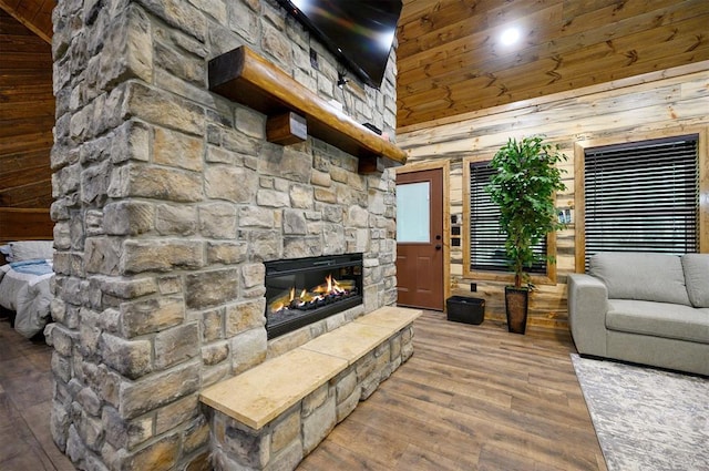 living room featuring wood ceiling, wood walls, high vaulted ceiling, a fireplace, and hardwood / wood-style flooring