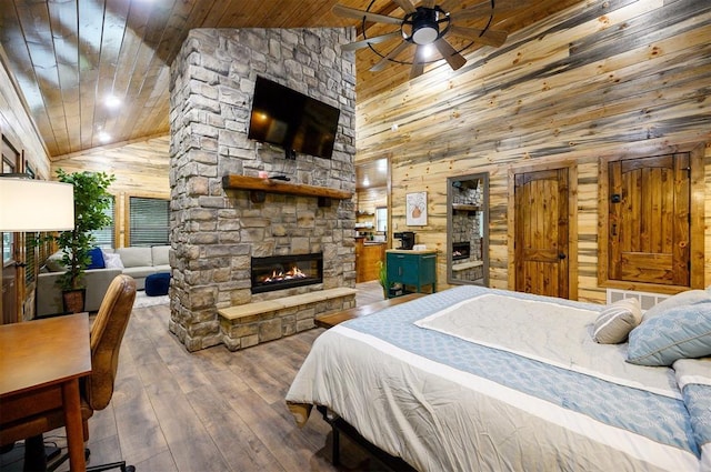 bedroom with wooden ceiling, a fireplace, wood-type flooring, wood walls, and high vaulted ceiling