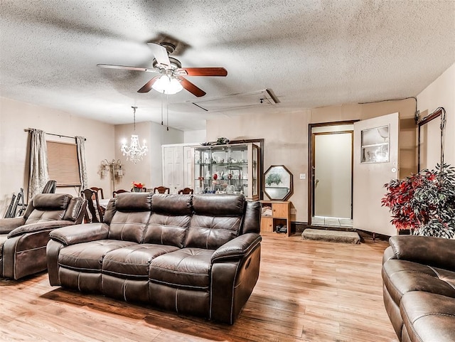 home theater with a textured ceiling, light hardwood / wood-style floors, and a notable chandelier