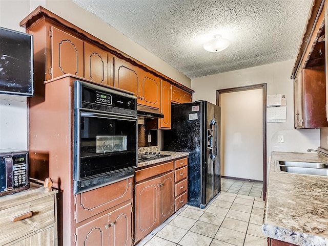 kitchen with a textured ceiling, light tile patterned floors, black appliances, and sink