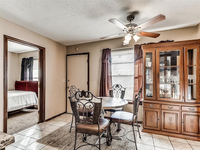 dining room featuring ceiling fan, a textured ceiling, and light tile patterned floors