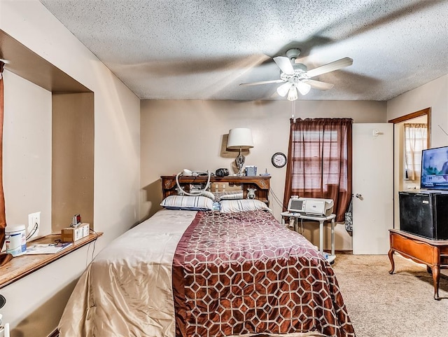 carpeted bedroom featuring ceiling fan and a textured ceiling