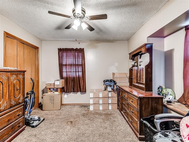 carpeted bedroom featuring a textured ceiling and ceiling fan