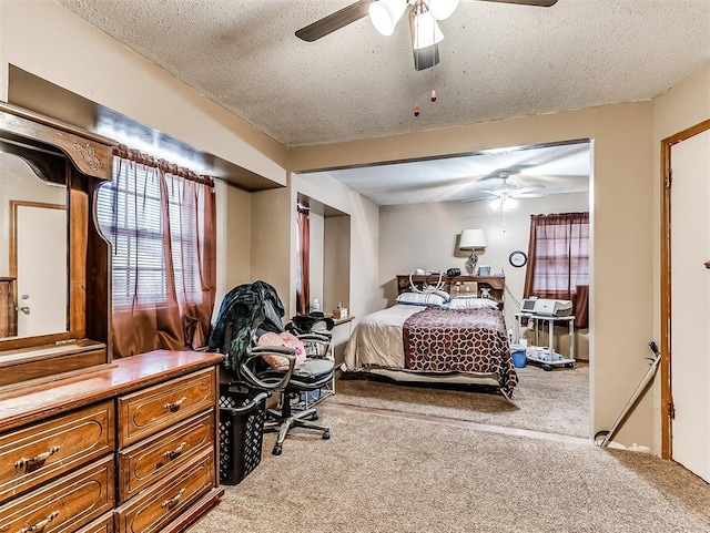 bedroom with a textured ceiling, ceiling fan, and carpet floors