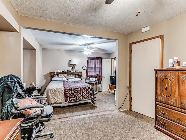 bedroom featuring ceiling fan, light colored carpet, and a textured ceiling