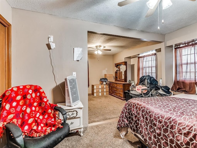 bedroom with ceiling fan, carpet, and a textured ceiling