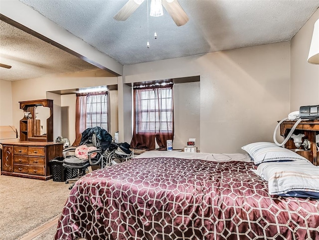 carpeted bedroom featuring ceiling fan and a textured ceiling